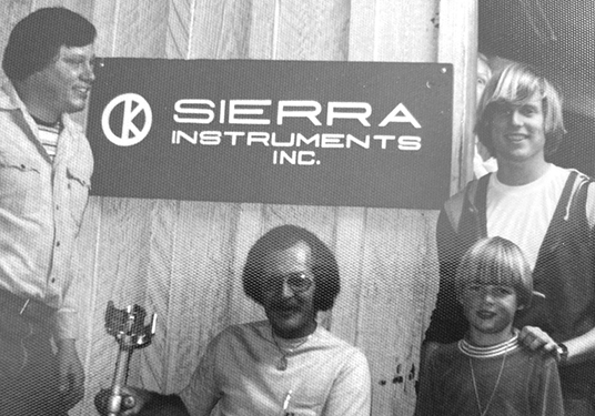 Dr. John Olin in Carmel in front of the Sierra logo